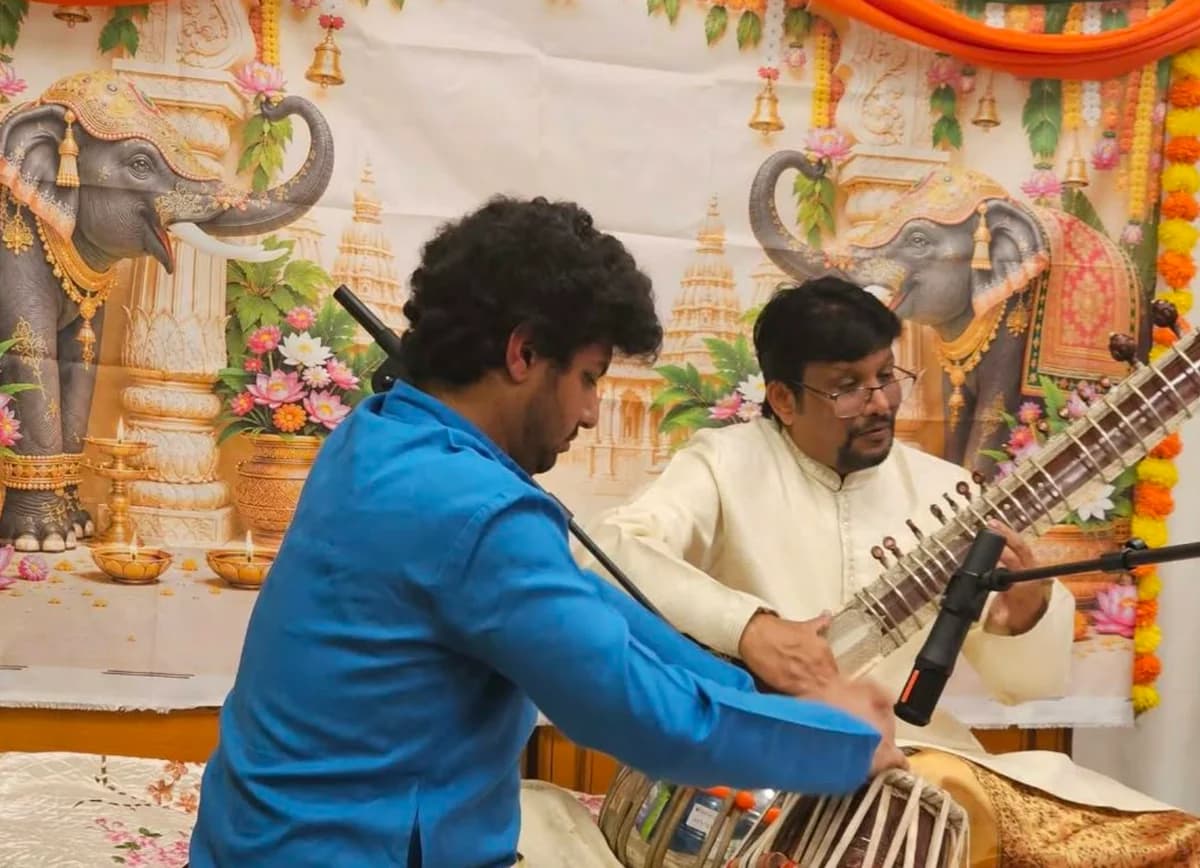 Pandit Sanjeev Korti playing sitar alongside a tabla player at the concert.